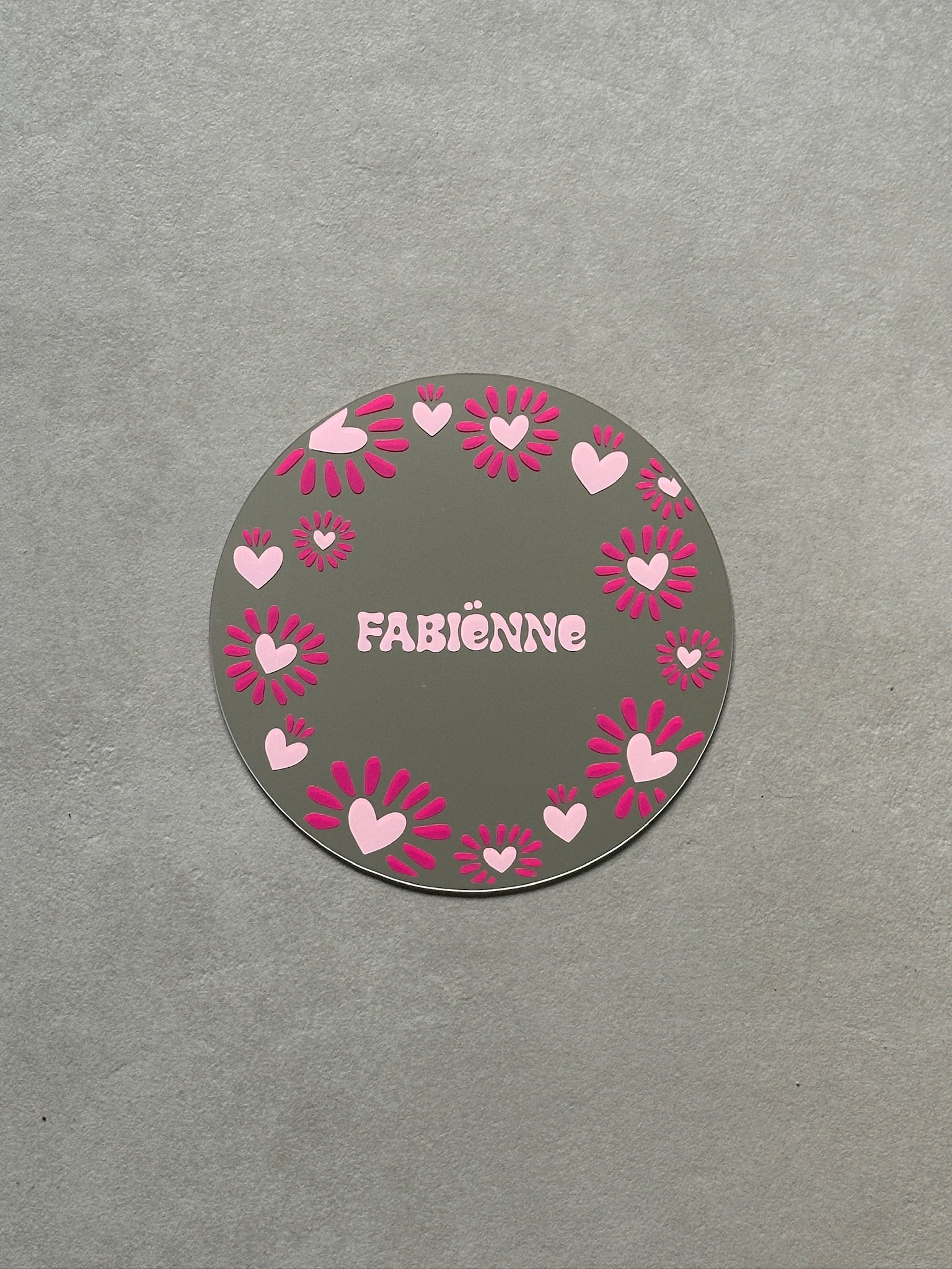 Custom sunheart spiegel met babypink hartjes en fucsia streepjes eromheen met in het midden een babypink naam.
