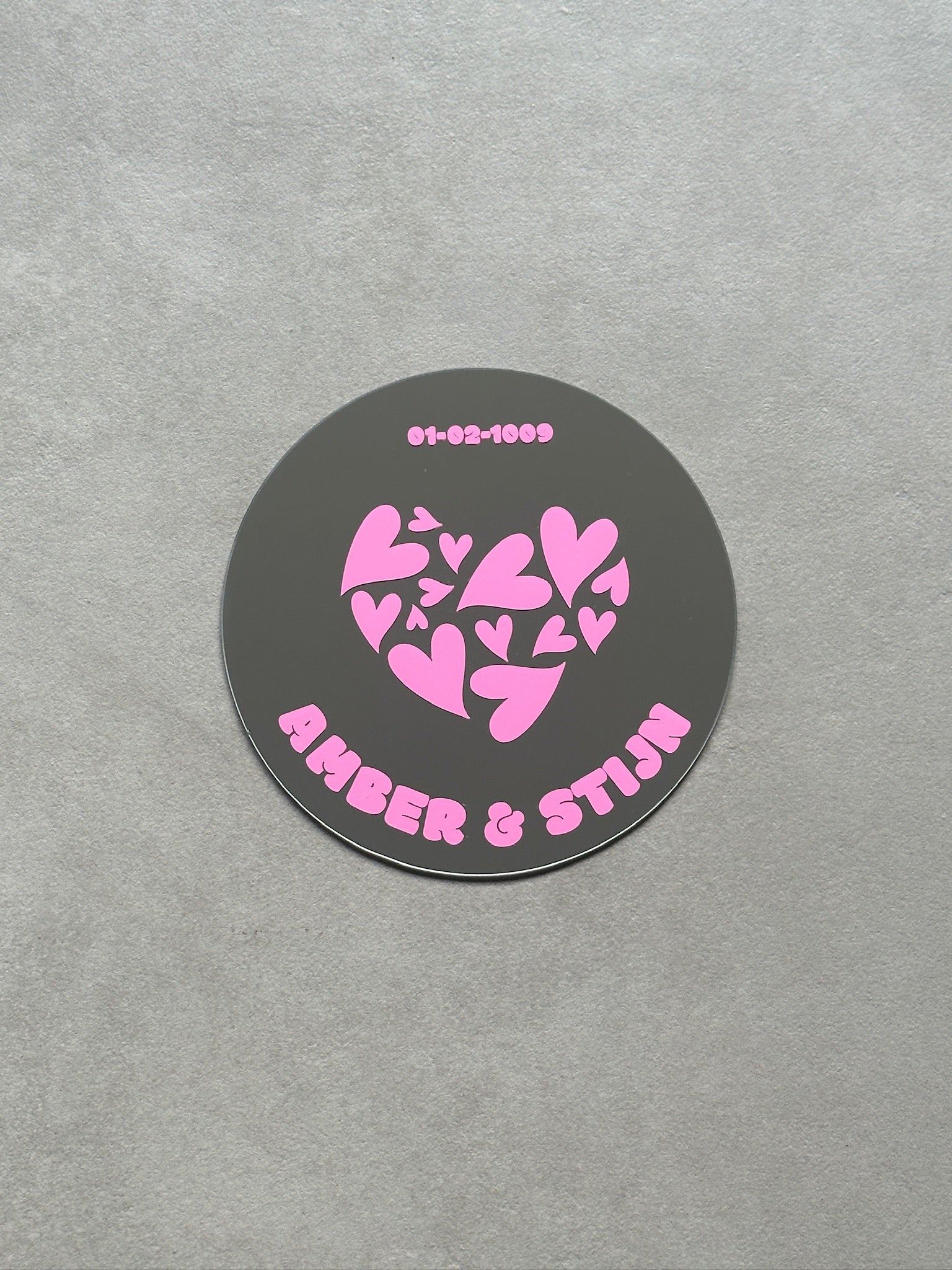 Custom relatie spiegel met in het midden een hartje bestaande uit kleinere hartjes. Met datum en twee namen. In de kleur roze/pink.