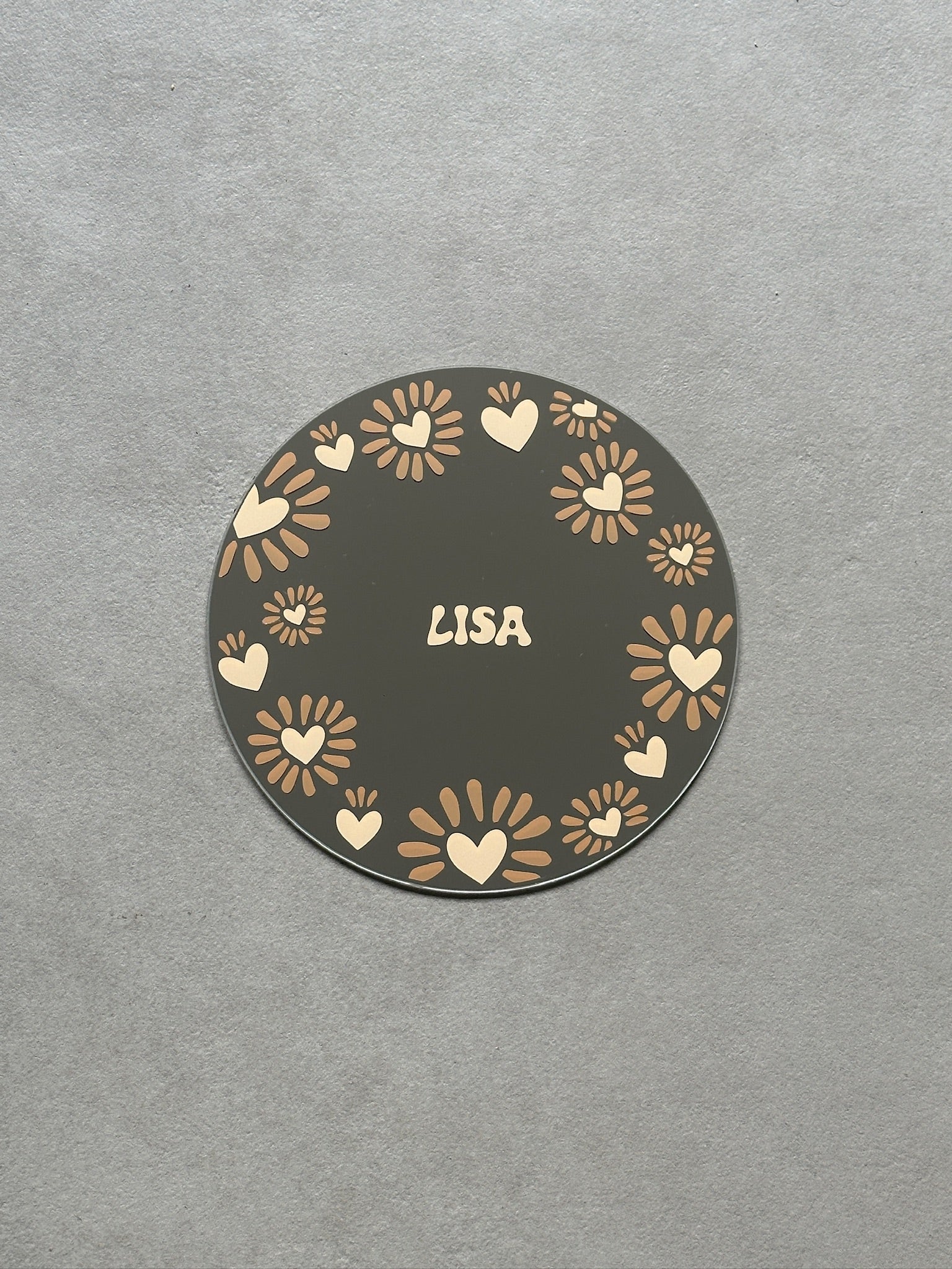 Custom sunheart spiegel met zandkleurige hartjes en caramel streepjes eromheen met in het midden een zandkleurige naam.